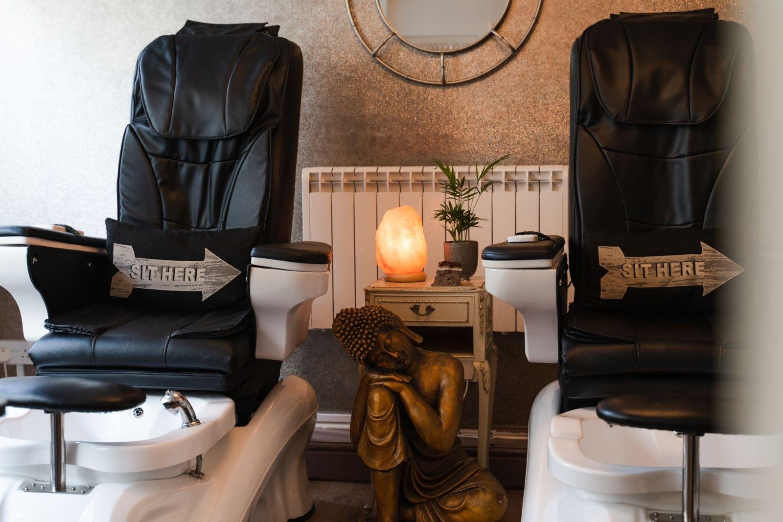 Pedicure spa chairs beside a glowing salt lamp