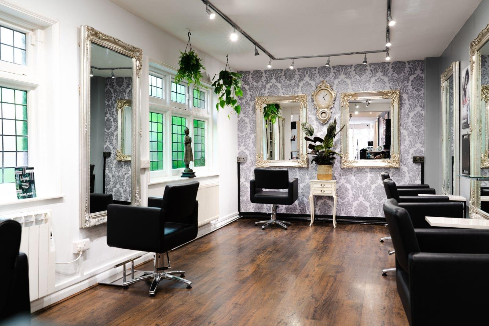 Serenity's salon floor with gold mirrors and styling chairs